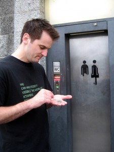 man outside pay toilet